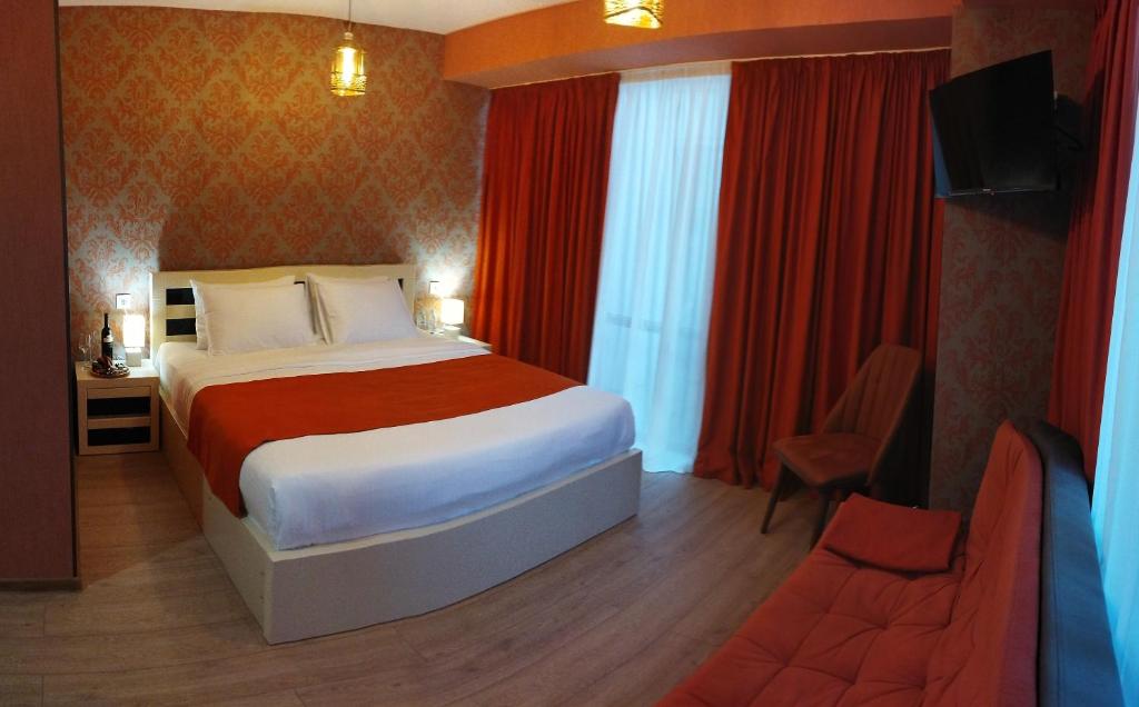 een hotelkamer met een groot bed en een televisie bij Vere Corner Hotel in Tbilisi City