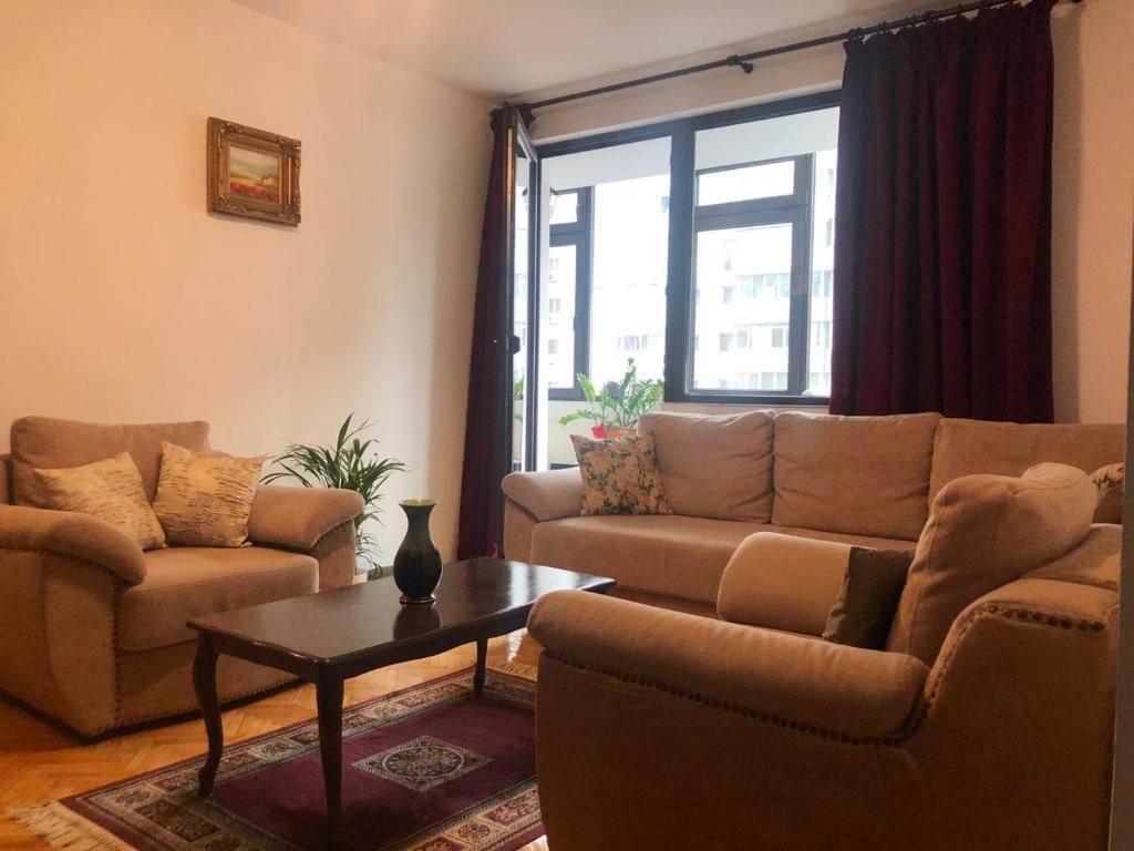 a living room with a couch and a table at Marie Apartment in Bucharest