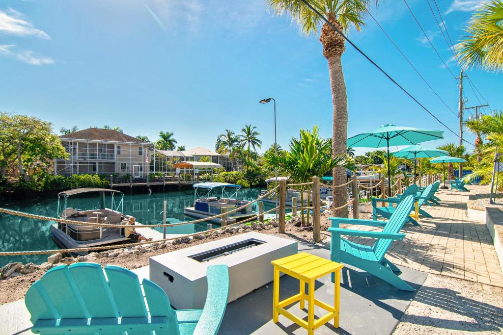 um grupo de cadeiras e mesas ao lado de uma marina em Latitude 26 Waterfront Resort and Marina em Fort Myers Beach