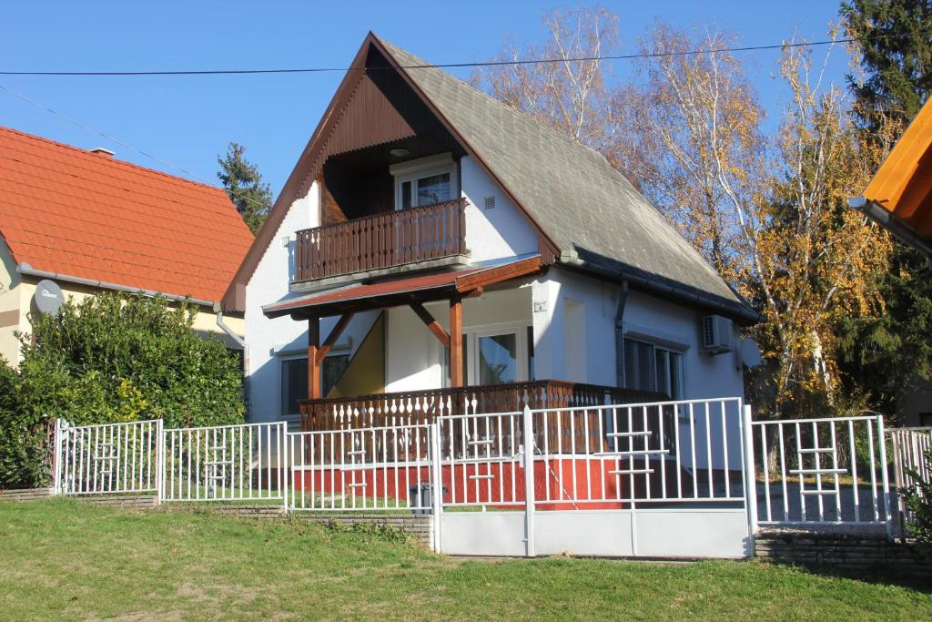 una casa con una cerca blanca delante de ella en Borbála Vendégház Igal, en Igal