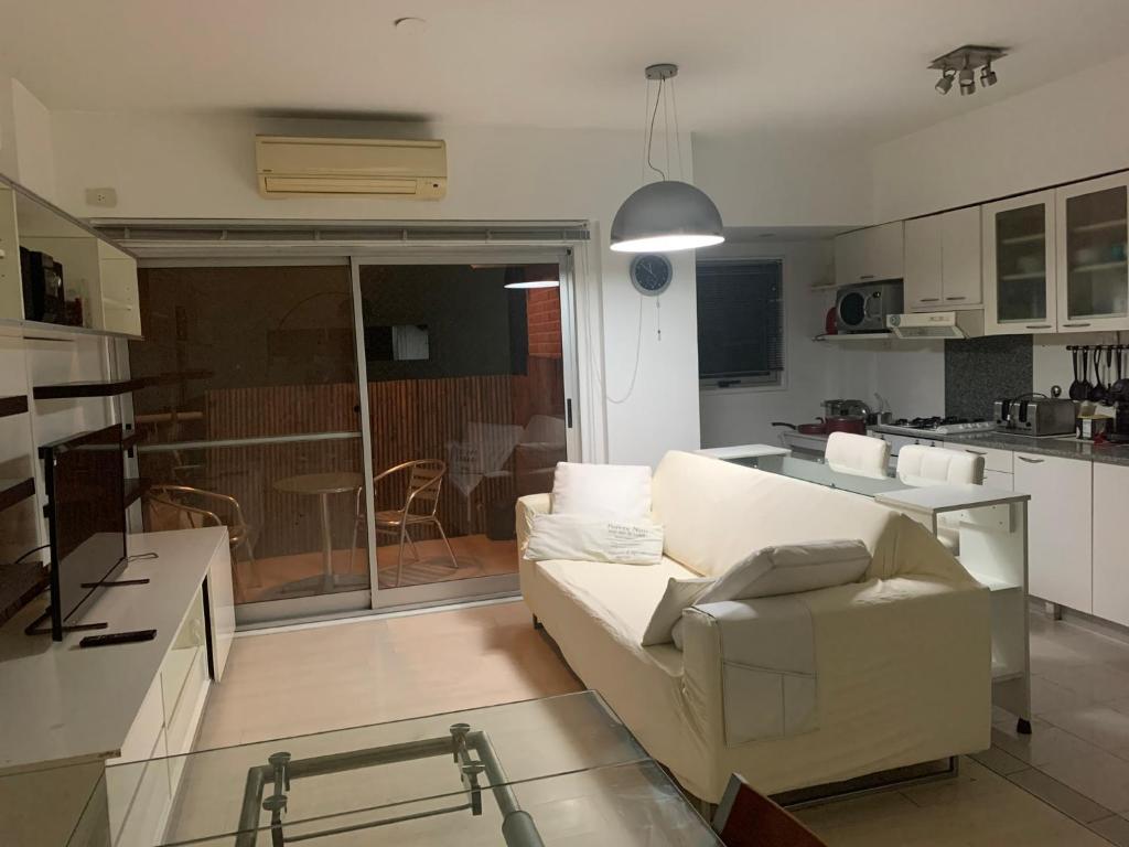 sala de estar con sofá blanco y cocina en Cañitas 3amb cochera fija techada solo CON RESERVA en Buenos Aires