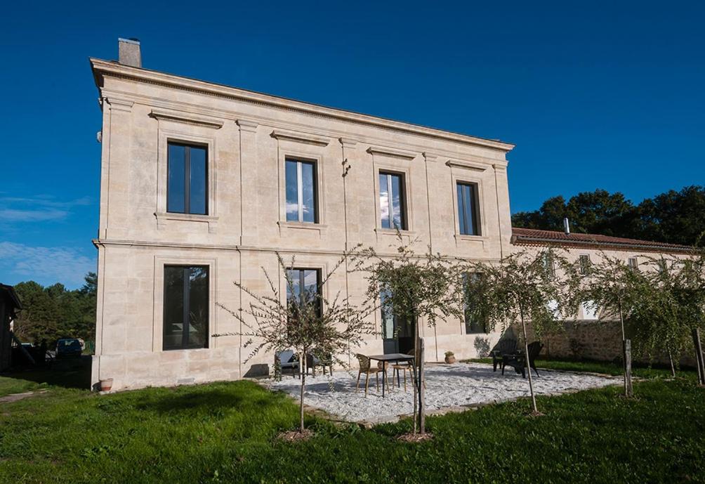 een groot stenen huis met bomen ervoor bij Villa Courreau - Maison de maitre in Vendays-Montalivet