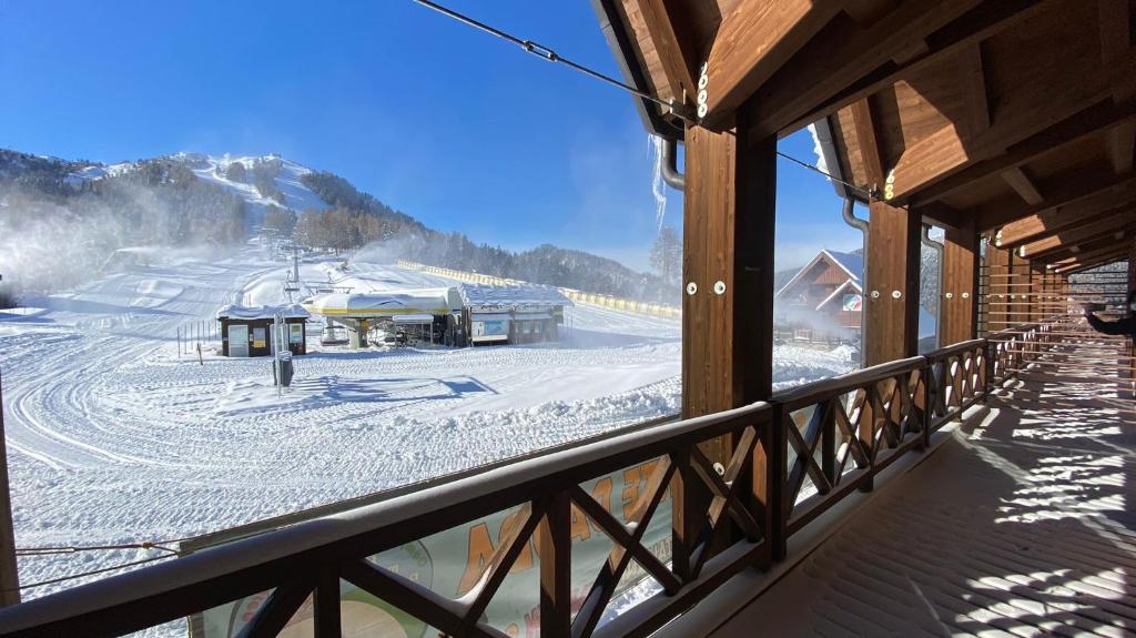 einen Balkon mit Blick auf einen schneebedeckten Berg in der Unterkunft Hotel Enzo Moro in Sùtrio