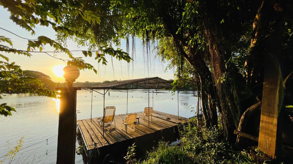 a dock with chairs on it on a body of water at Moon River Resort Phimai in Pi Mai
