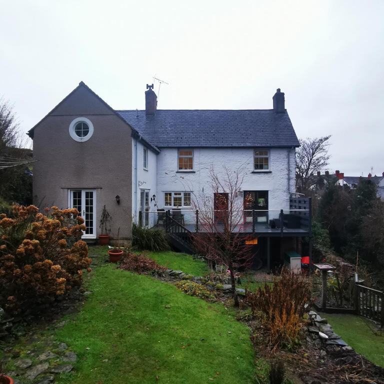 a white house with a yard in front of it at Rooms by the River at Glan Aber in Cynwyd