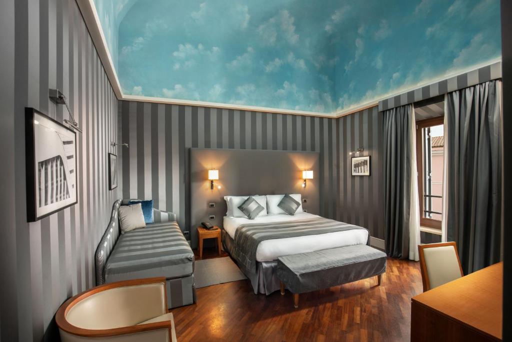 a hotel room with a bed and a chair at Monti Palace Hotel in Rome