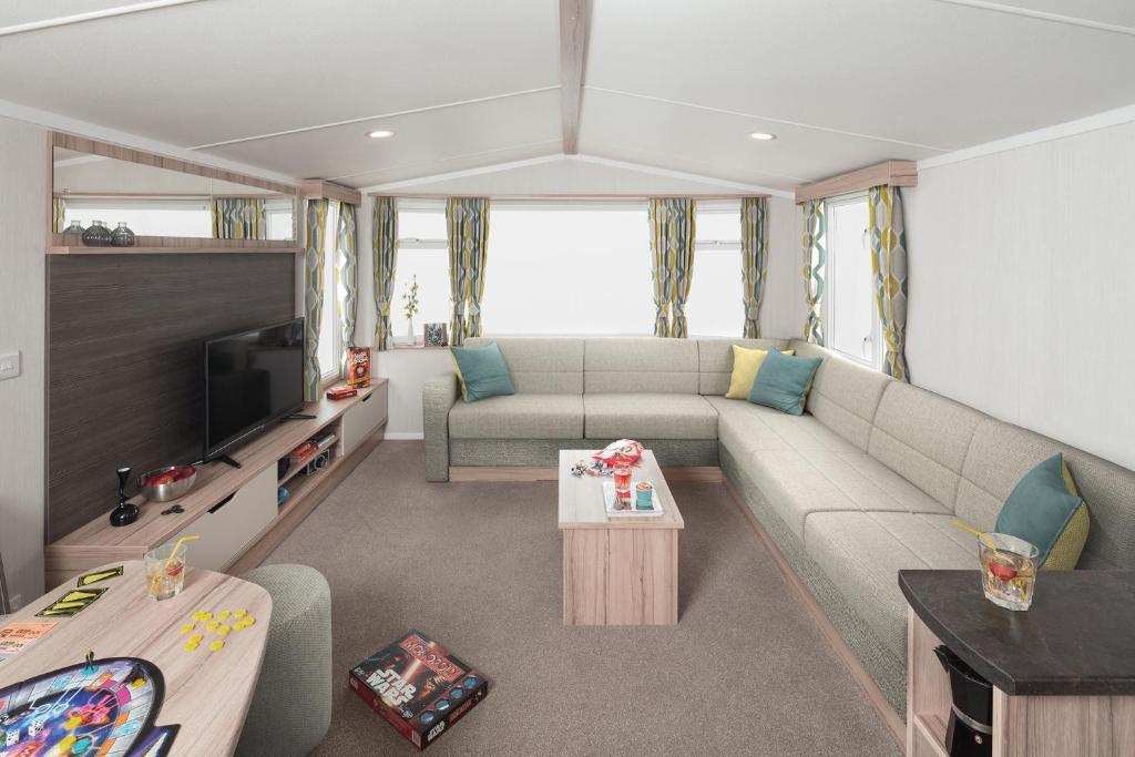 a living room with a couch and a tv at Three Bedroom Instow Caravan in Bideford