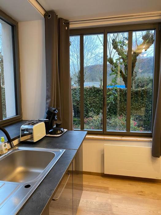 a kitchen with a sink and a large window at Gite l ORIGINE in Ornans