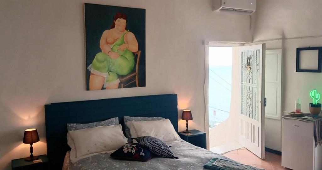 a bedroom with a bed and a painting on the wall at TakeAmalfiCoast Patchwork Rural House in Minori