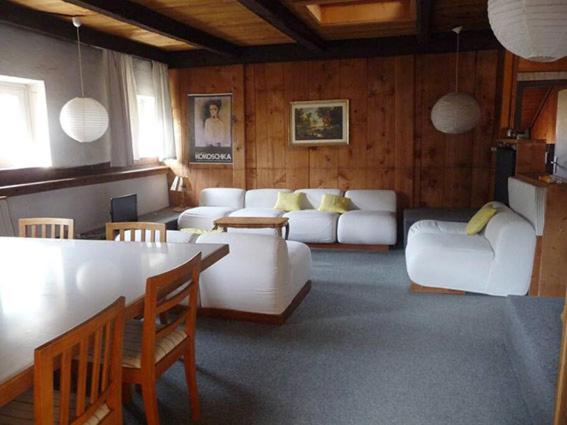 een woonkamer met witte banken en een tafel bij ATI Appartamento stile Chalet dell 800 nel cuore di Ortisei in Ortisei