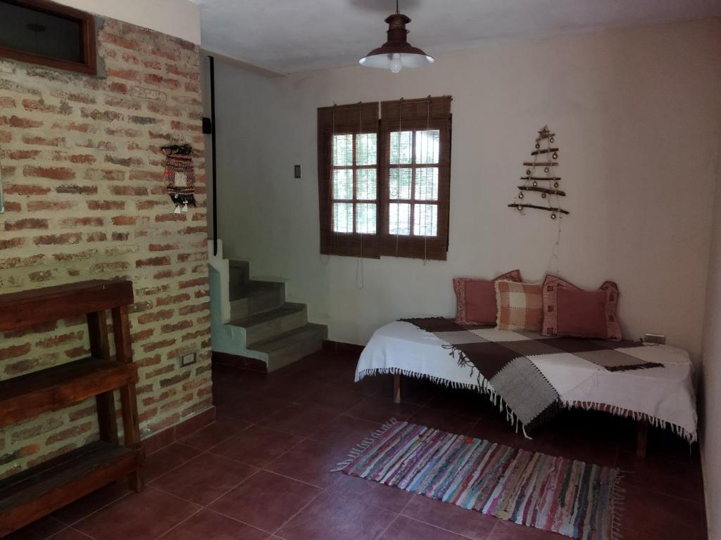 una habitación con una cama y una pared de ladrillo en Armonía, en Victoria