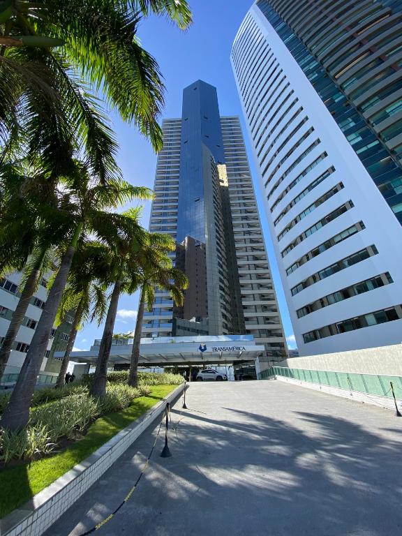 a street in a city with palm trees and buildings at Beach Class Internacional apartamento in Recife