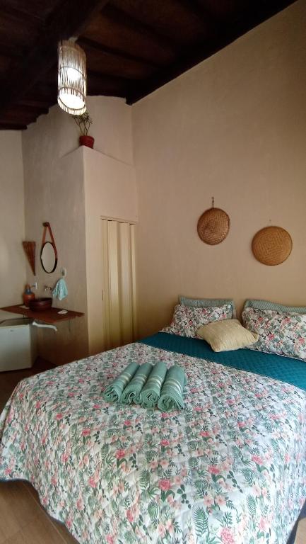 a bedroom with a large bed with a colorful bedspread at Canto do Sabiá PETAR Hospedagem in Iporanga