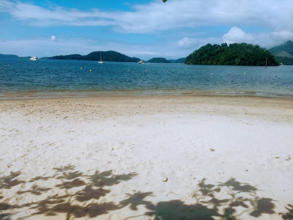 a view of a beach with trees in the water at Apartamento Condomínio Porto Bracuhy in Angra dos Reis