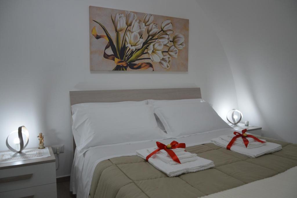 una camera da letto con un letto con due asciugamani e un quadro di Casa Nannina a Matera
