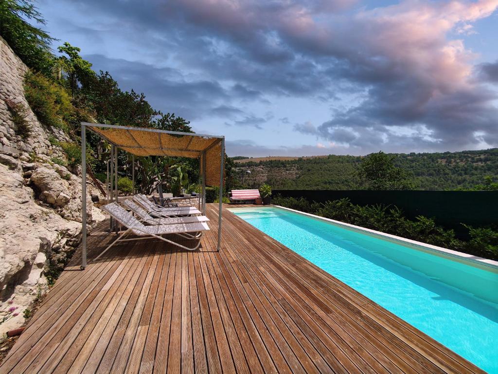 una piscina en una terraza de madera con tumbona en Innesti B&B, en Ragusa