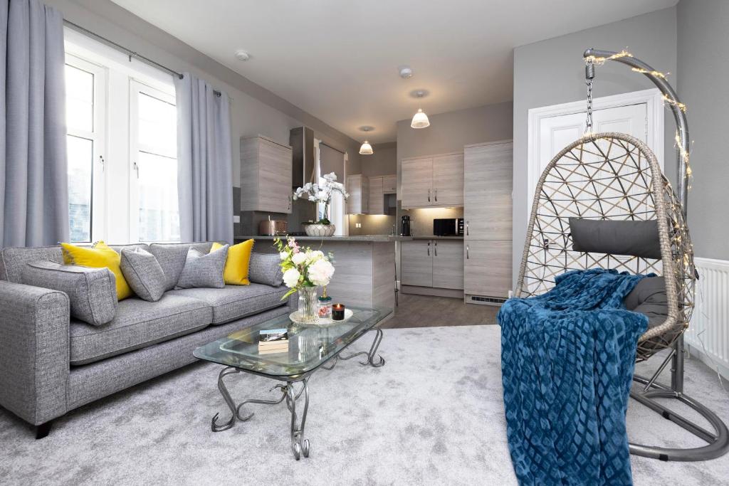 a living room with a couch and a table at Stylish George Street Apartment in Peebles