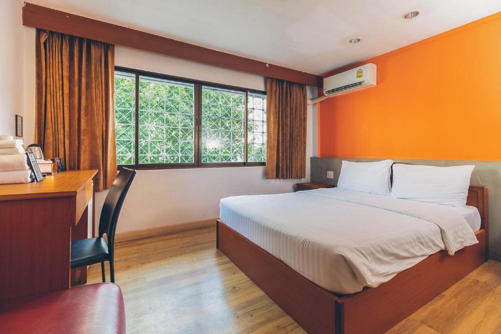 1 dormitorio con cama, escritorio y ventana en Atlas Bangkok Hotel, en Bangkok