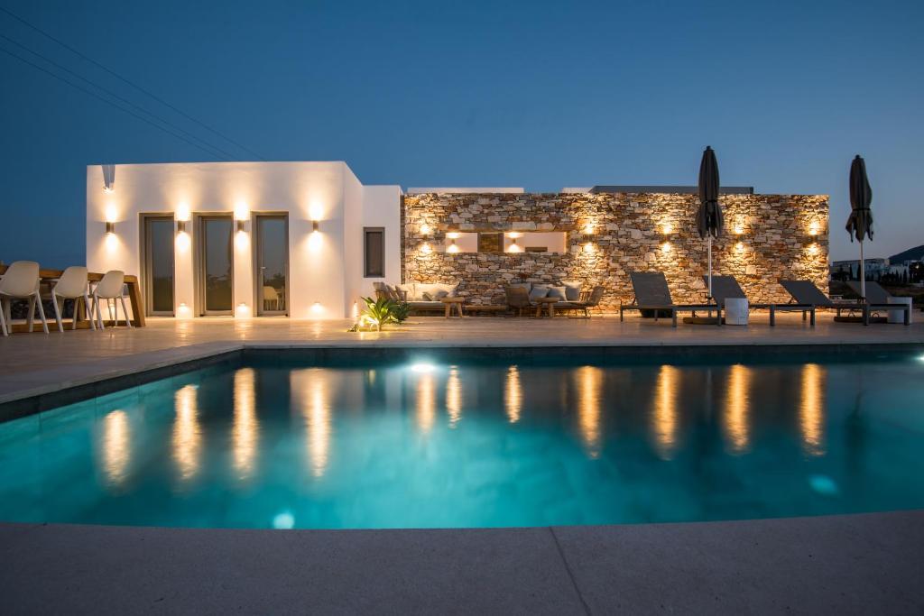 a villa with a swimming pool at night at Bracket House Paros in Dhragoulás