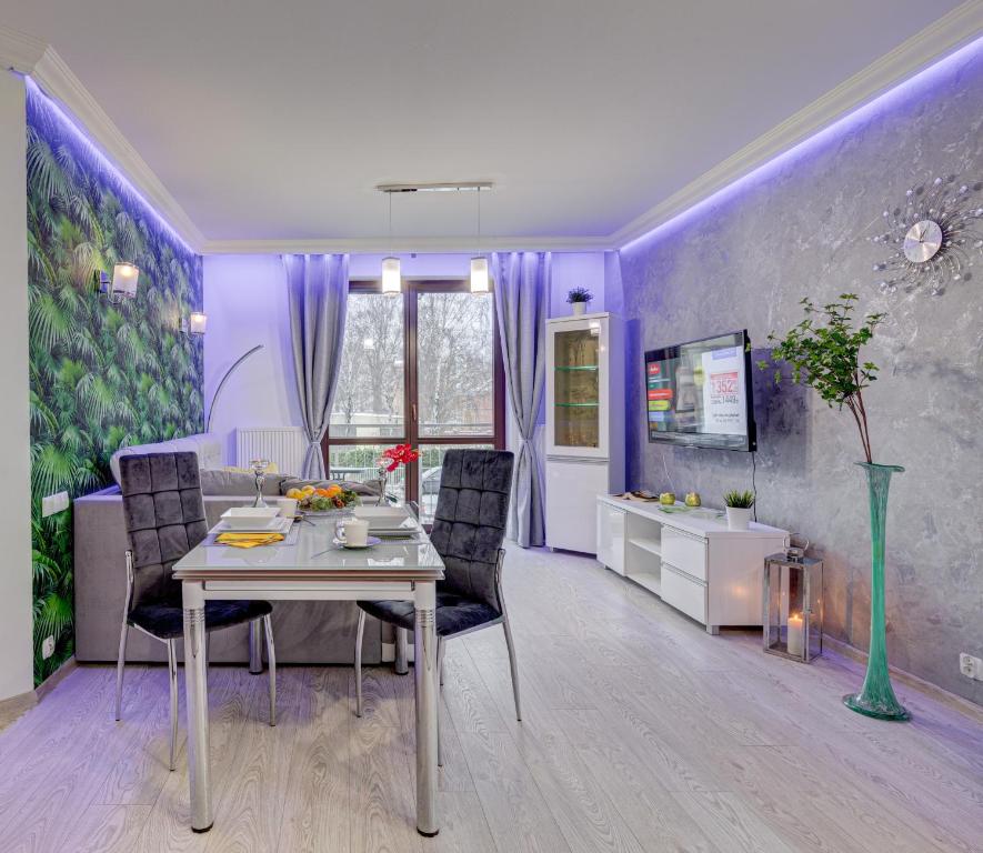 a dining room with purple walls and a table and chairs at Apartamenty Silver in Szczecin