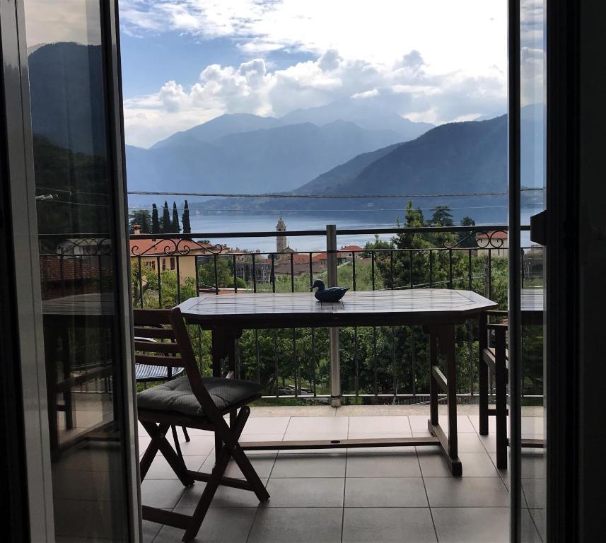 a table and a chair on a balcony with a view at VILLA AS Campo Marzio in Lenno