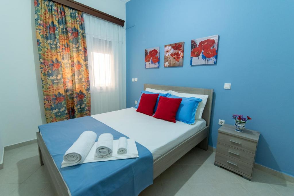 um quarto azul com uma cama com almofadas vermelhas e azuis em Nikopoleos 41 em Preveza