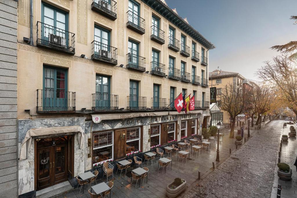 a building with tables and chairs on a street at Miranda & Suizo in San Lorenzo de El Escorial