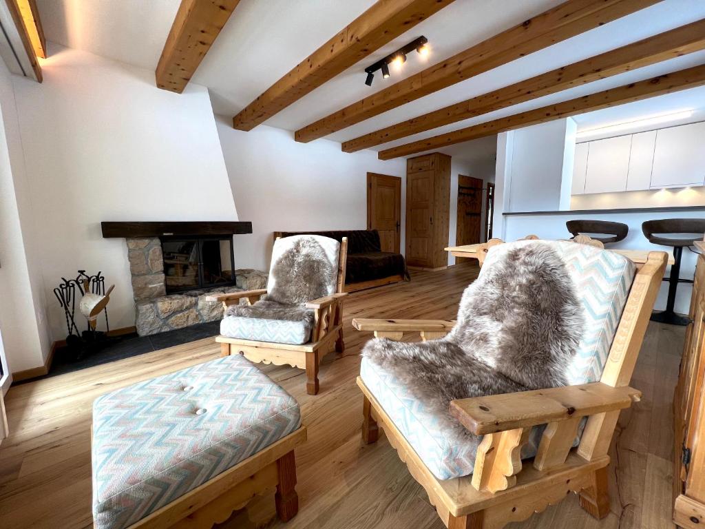 a living room with two chairs and a fireplace at Cosy Apartment facing Piz Rosatsch in St. Moritz