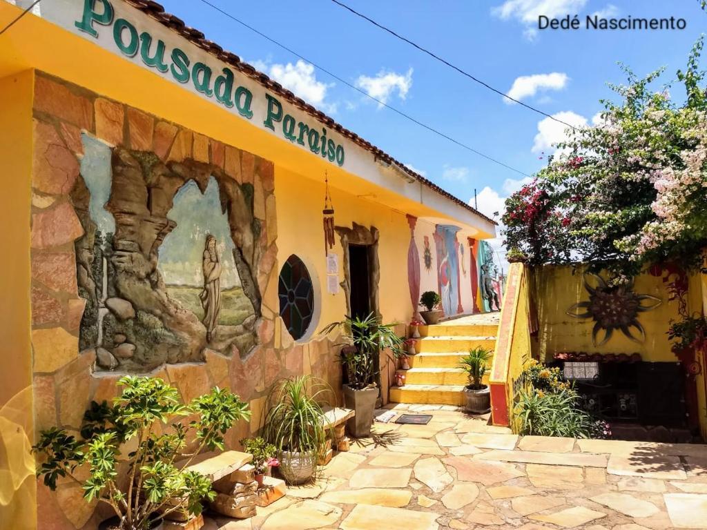 a building with a mural on the side of it at Pousada Paraíso São thome in São Thomé das Letras