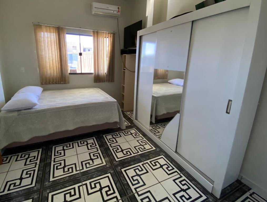 a small room with two beds and a mirror at Apartamento Centro in Ametista do Sul