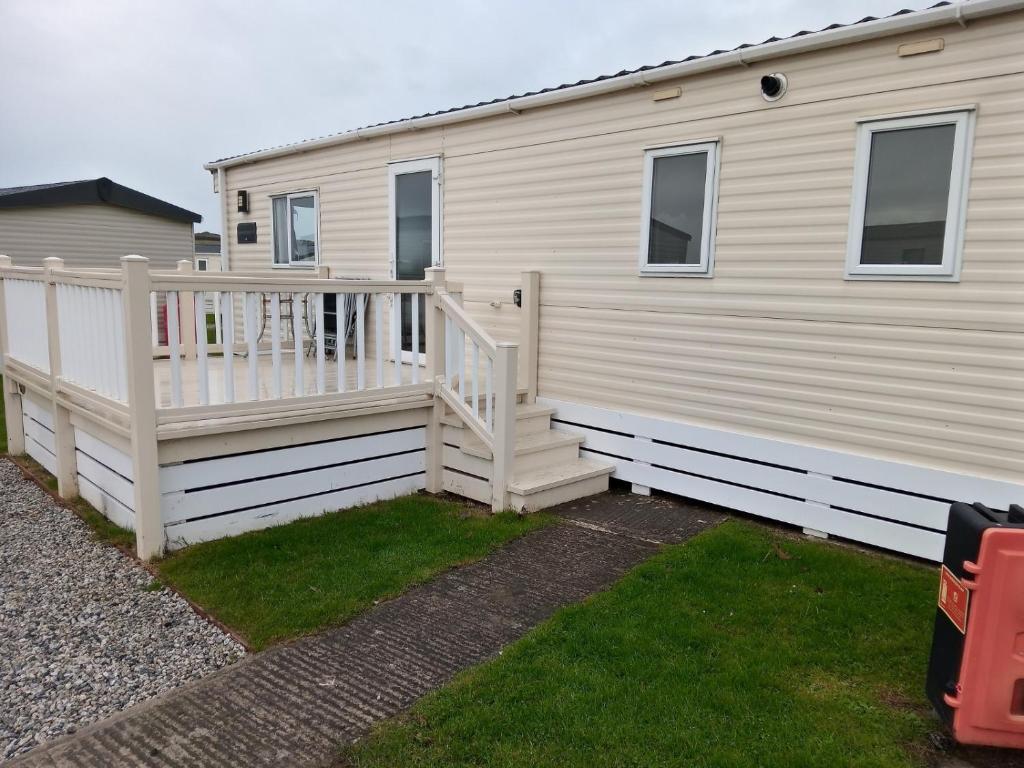 a mobile home with a staircase and a deck at Summer Breeze in Bude