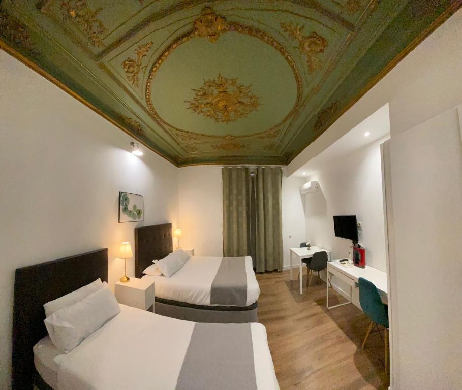 una camera d'albergo con due letti e un soffitto a cassettoni di Nice Dreams House a Madrid