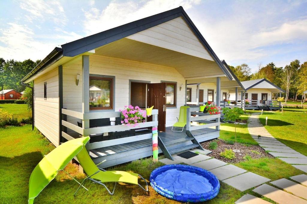 a tiny house with a porch and a yard at Holiday resort, Jaroslawiec in Jarosławiec