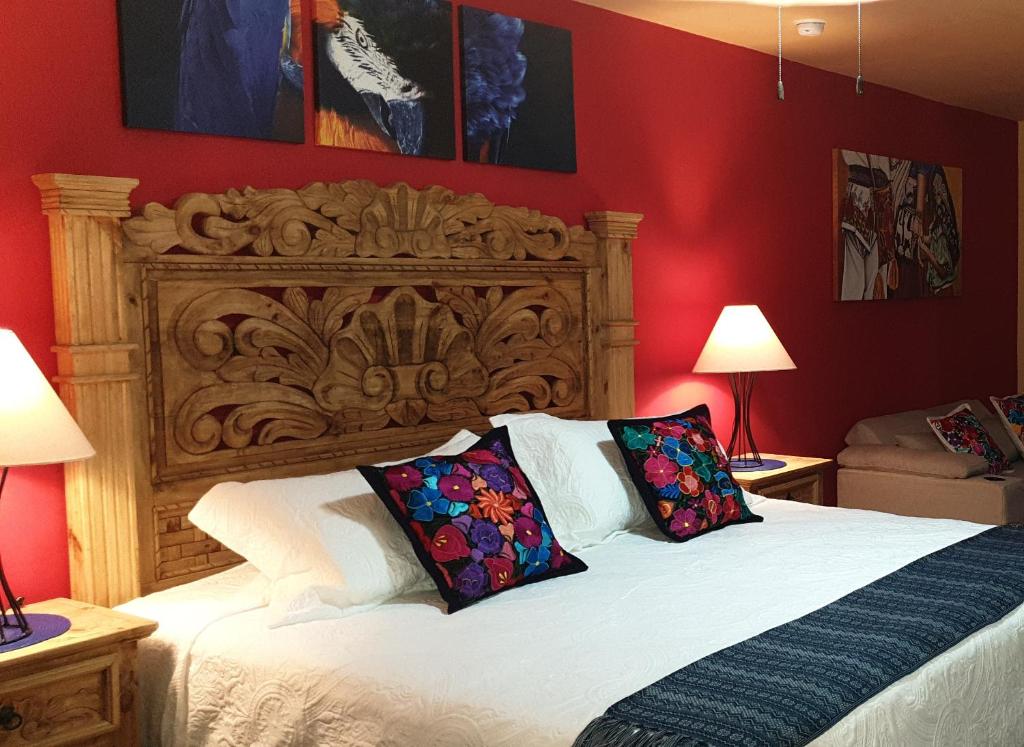 - une chambre avec un grand lit et une tête de lit en bois dans l'établissement La Casona Chapala, à Chapala