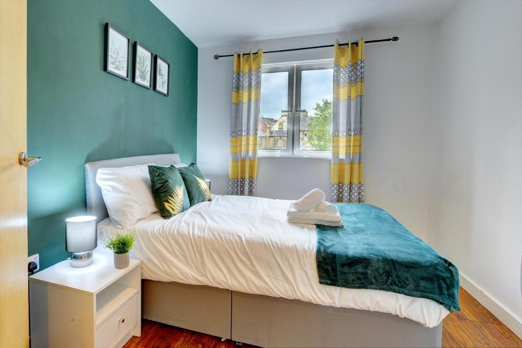 1 dormitorio con cama y ventana en City Centre Apartment with Secure Parking by MBiZ, en Northampton