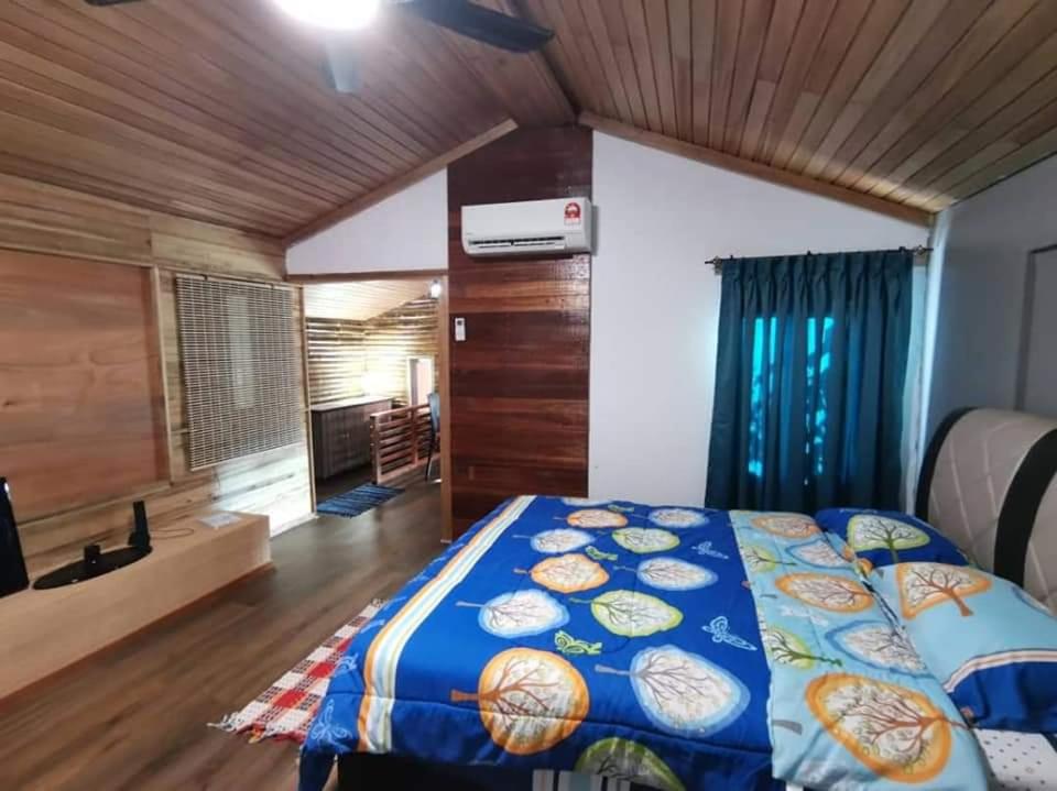 SimanggangにあるCassava Homestay - Rumah Galleryの木製の天井が特徴のベッドルーム1室(ベッド1台付)