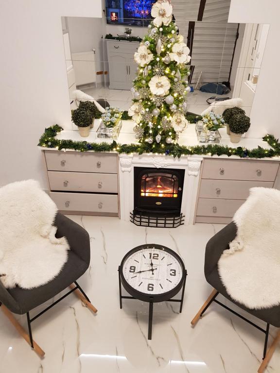a living room with a christmas tree and a fireplace at Duplex Marquis in Braşov