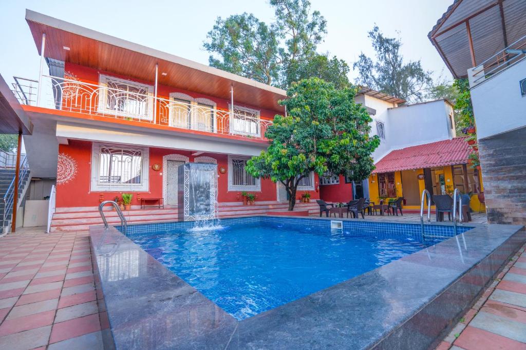 a swimming pool in front of a house at Flora Ecostay Resort and Spa Lonavala in Lonavala