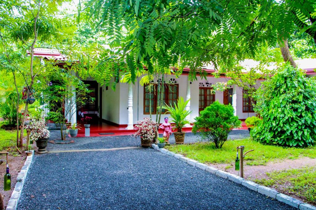 een loopbrug naar een huis in een tuin bij Thathsara Holiday Inn in Sigiriya