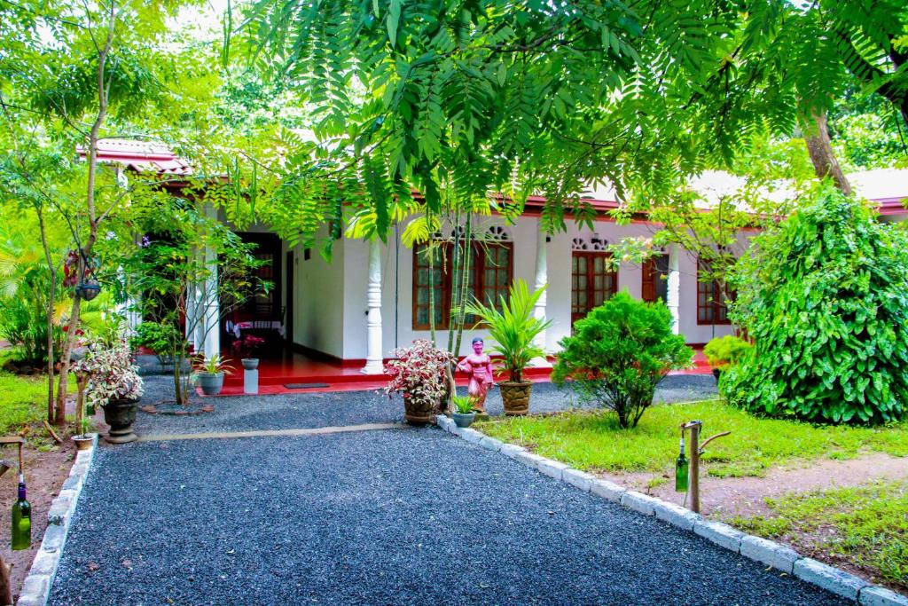 a walkway leading to a house in a garden at Thathsara Holiday Inn in Sigiriya