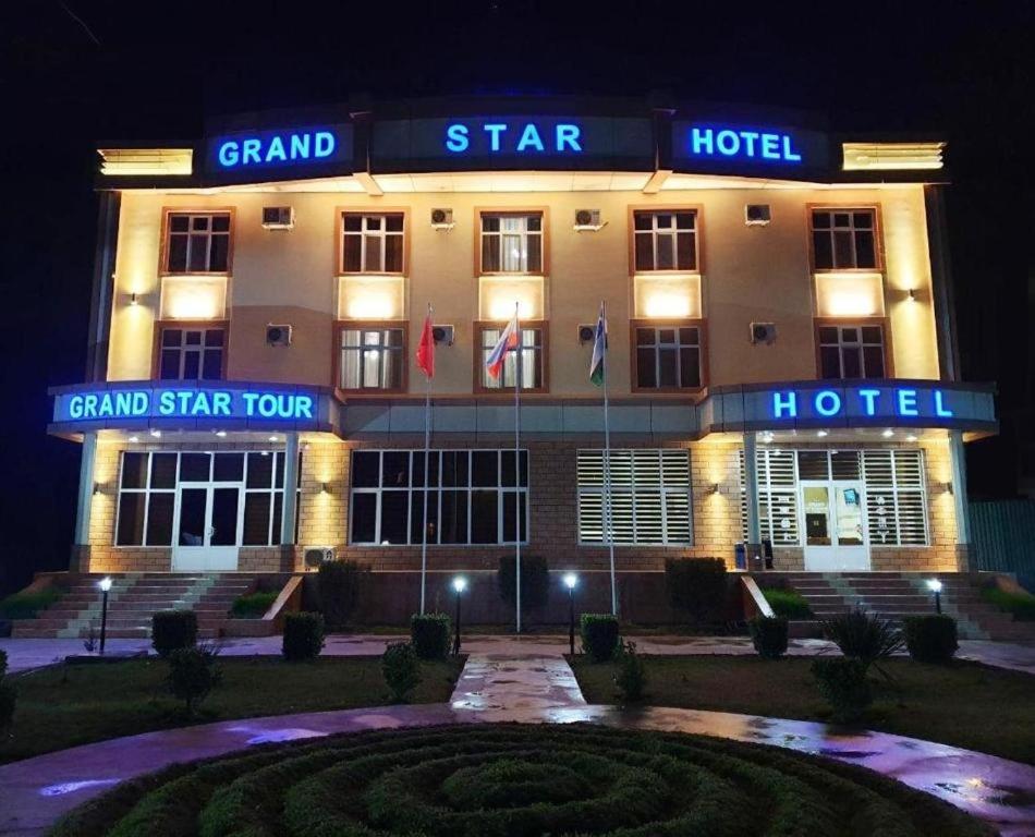 ein Grand Sterne Hotel wird nachts beleuchtet in der Unterkunft GRAND STAR HOTEL in Qarshi