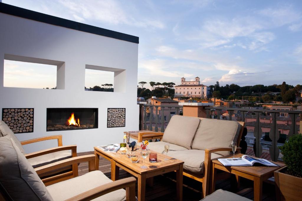a balcony with chairs and a fireplace with a view at Portrait Roma - Lungarno Collection in Rome