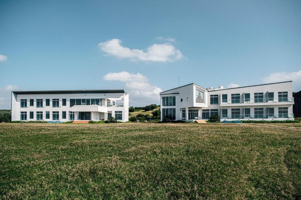 due grandi edifici bianchi con un prato di Sunlight On the Peninsula a Eluan