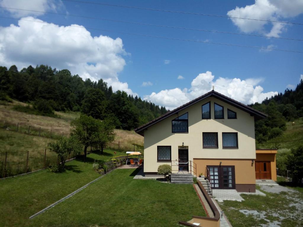 een huis op een heuvel met een tuin bij Windstille in Oščadnica