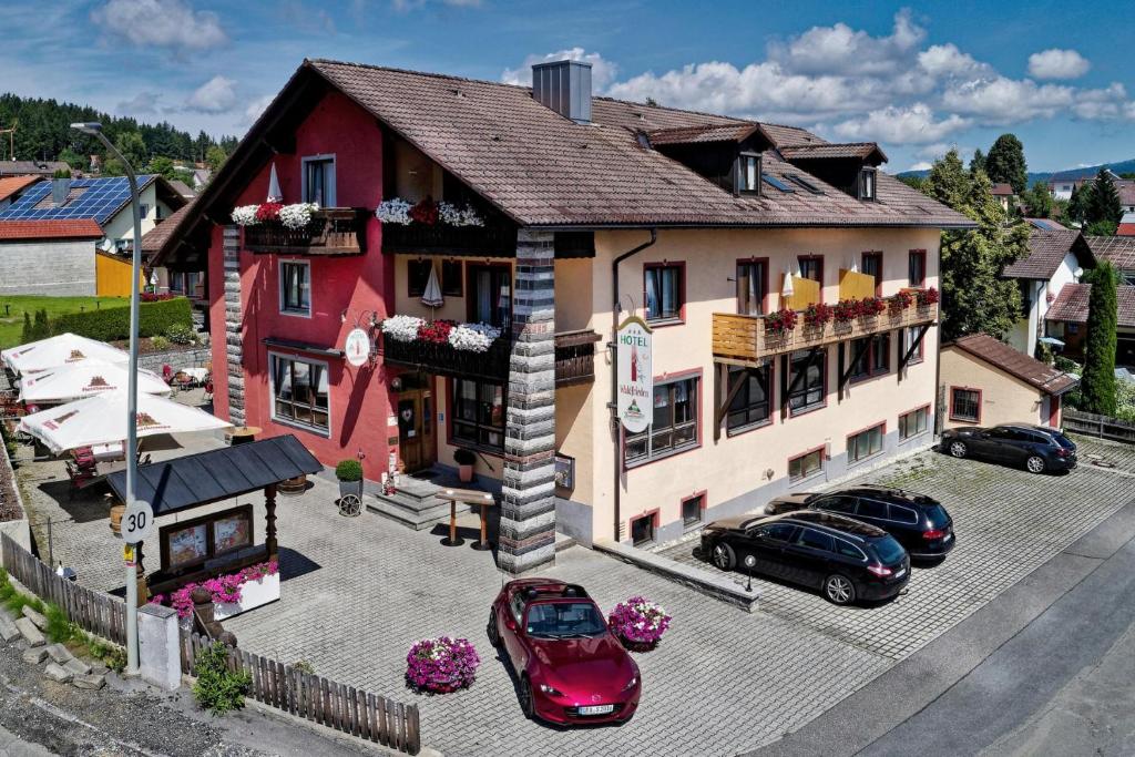 シュピーゲラウにあるHotel Waldfrieden "Das kleine Hotel"の駐車場車の入った建物