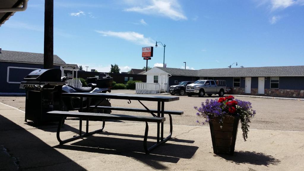 a picnic table and a grill in a parking lot at St. Paul Lodge in St. Paul