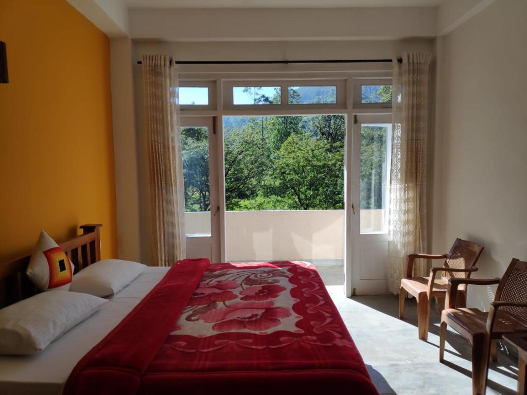 a bedroom with a bed and a large window at Queensark in Nallathanniya