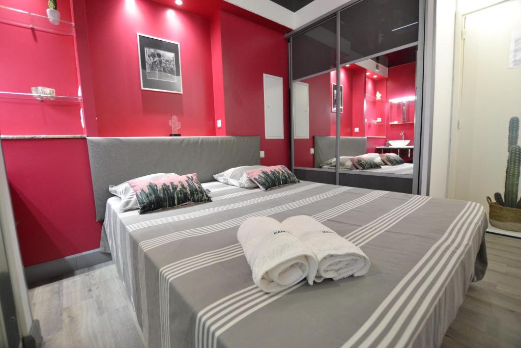 - une chambre avec 2 lits aux murs rouges dans l'établissement Studio Naturiste "LE CACTUS" Coursives Port Nature 614, au Cap d'Agde