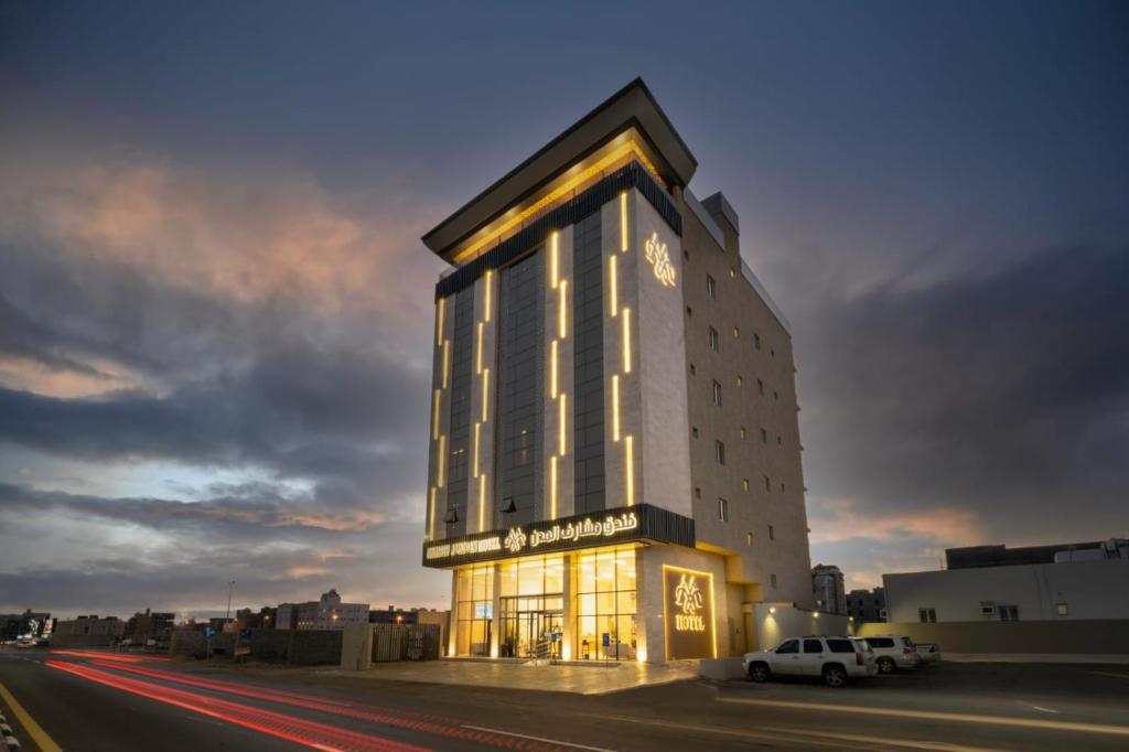 un grand bâtiment avec une horloge sur son côté dans l'établissement Msharef almoden hotel فندق مشارف المدن, à Jazan
