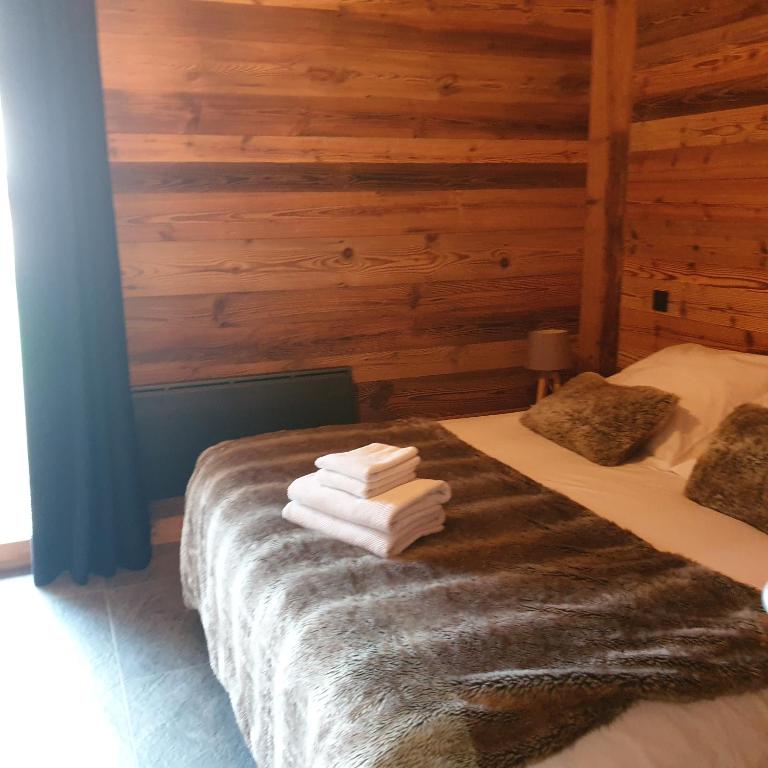 una camera da letto con un letto e asciugamani di CHALET MARY a Essert-Romand